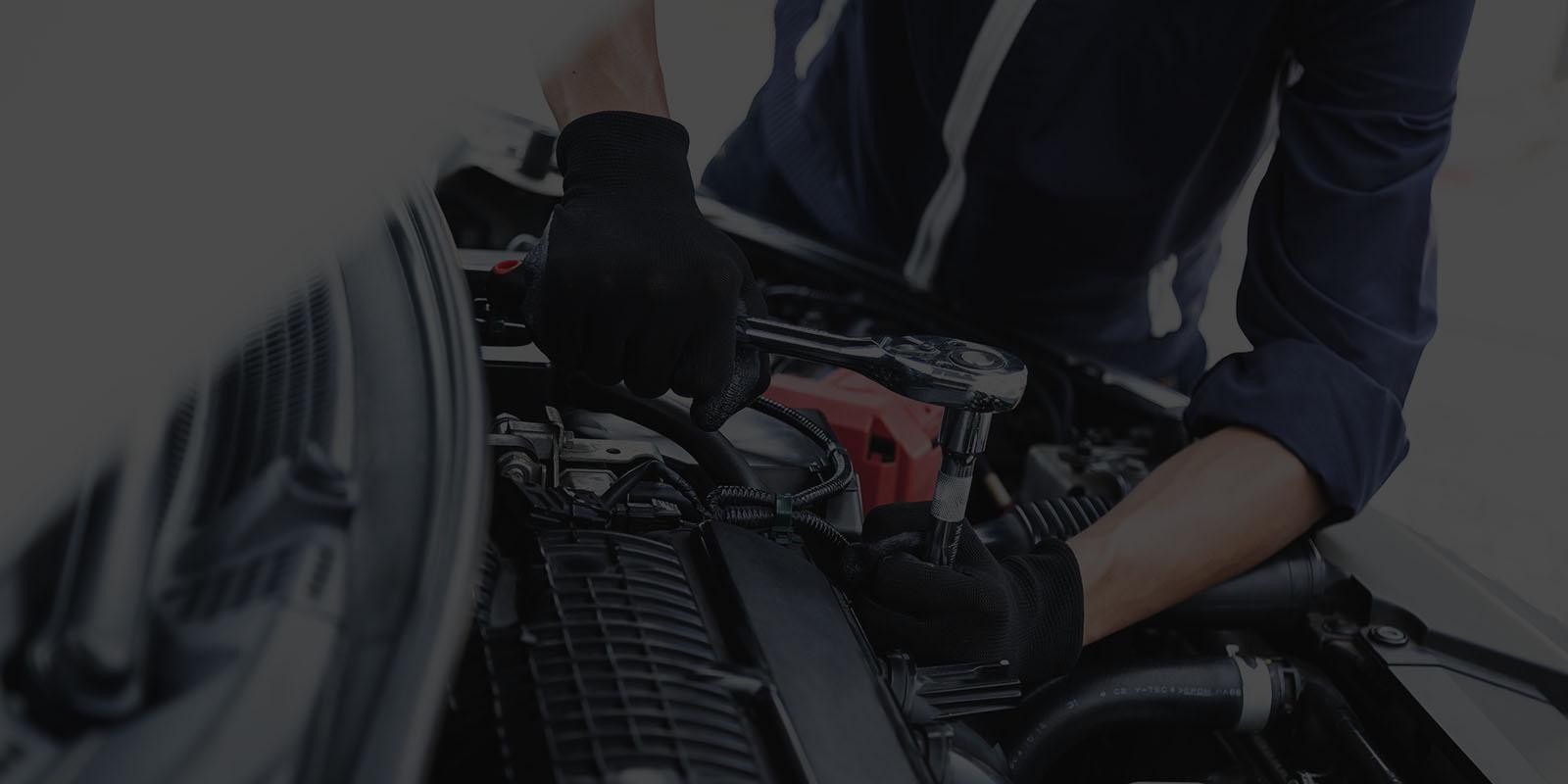 Automobile mechanic repairman hands repairing a car engine